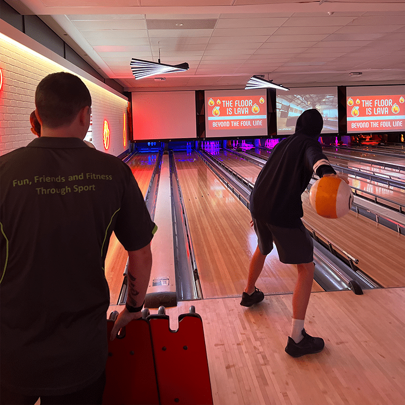 A person about to throw a bowling ball at ten pin bowling